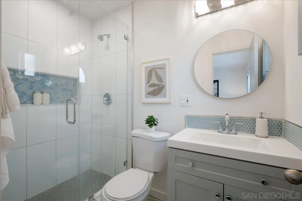 941 8th Street Imperial Beach, CA 91932 - Photo 14 of 22 a bathroom with a sink a mirror a toilet and shower