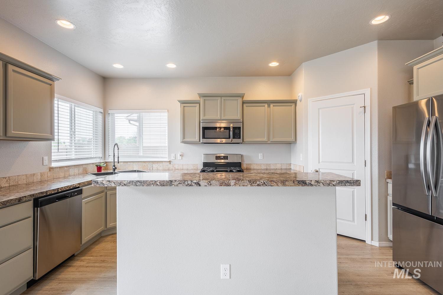 2515 Fallcrest Street Caldwell, ID 83607 - Photo 11 of 48 Kitchen with stainless steel appliances, light wood-type flooring, a kitchen island, recessed lighting, and gray cabinets