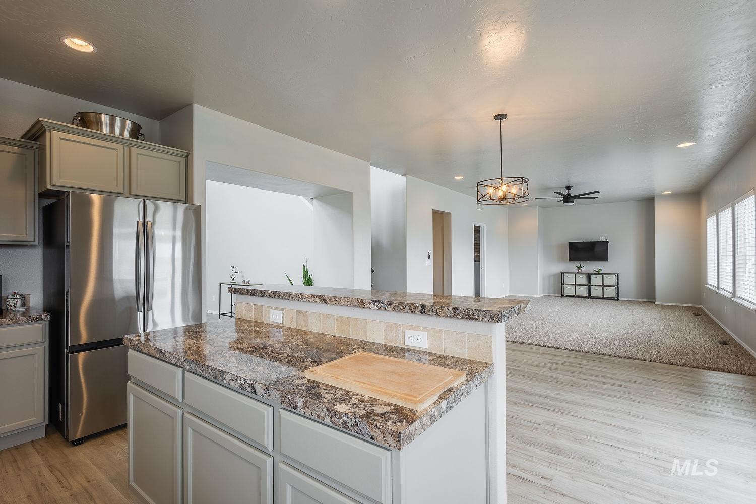2515 Fallcrest Street Caldwell, ID 83607 - Photo 48 of 48 Kitchen featuring freestanding refrigerator, open floor plan, light wood-style flooring, ceiling fan, and gray cabinetry