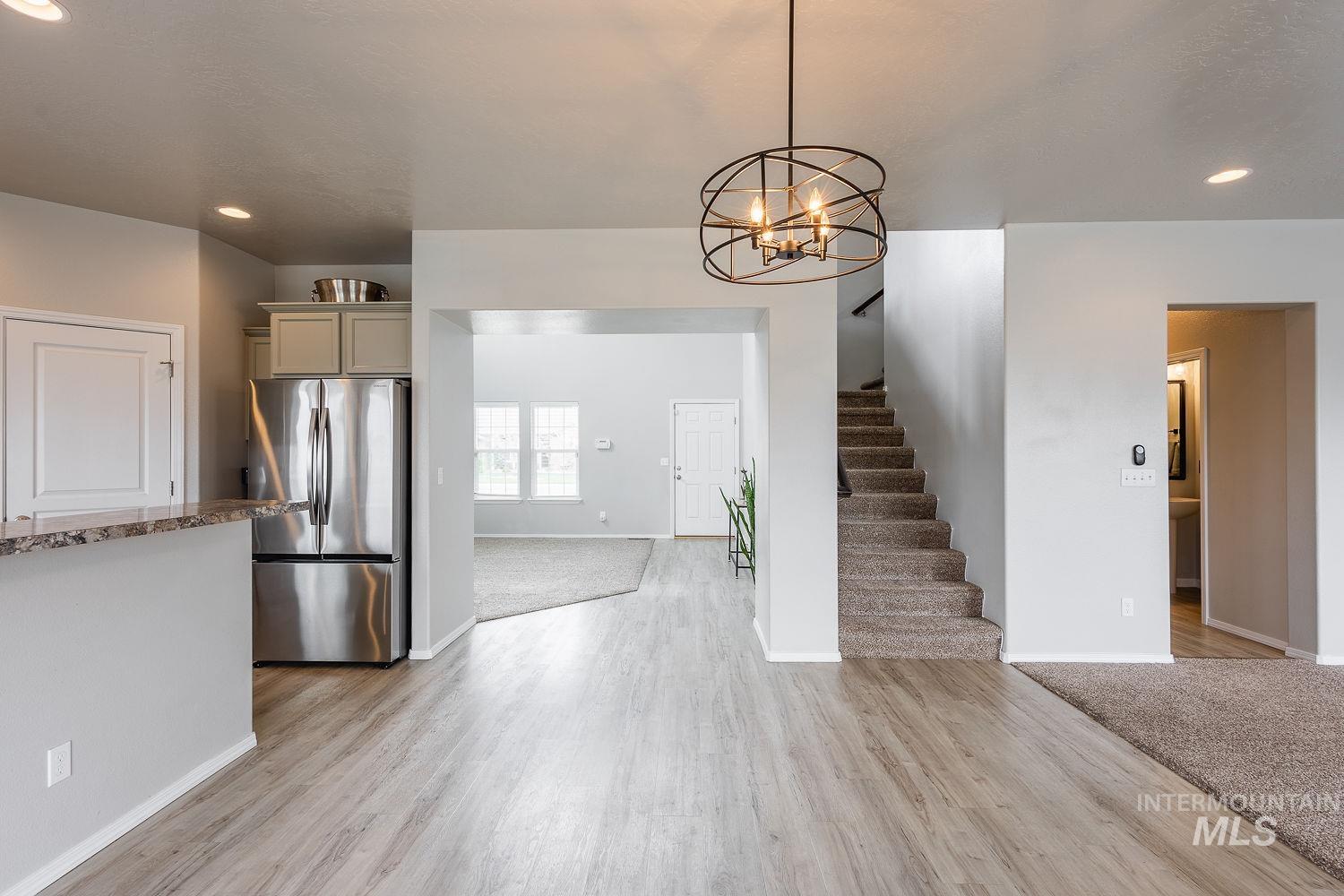 2515 Fallcrest Street Caldwell, ID 83607 - Photo 17 of 48 Kitchen with freestanding refrigerator, a chandelier, light stone countertops, light wood-style floors, and gray cabinets