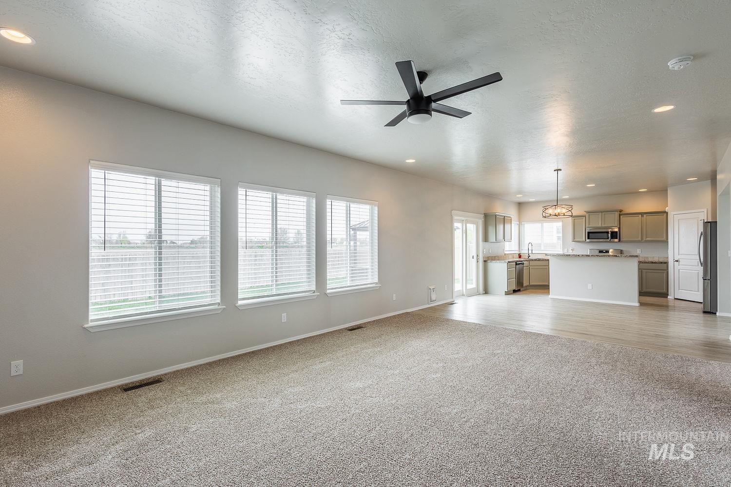 2515 Fallcrest Street Caldwell, ID 83607 - Photo 19 of 48 Unfurnished living room featuring recessed lighting, a textured ceiling, a ceiling fan, and light carpet