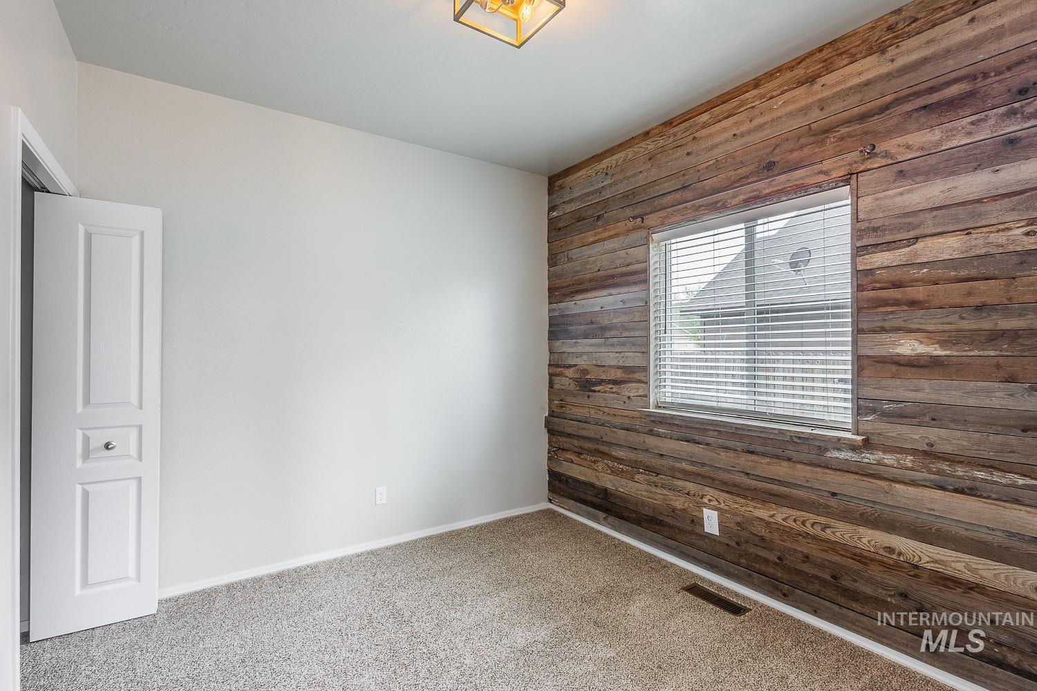 2515 Fallcrest Street Caldwell, ID 83607 - Photo 21 of 48 Carpeted spare room featuring wooden walls and baseboards