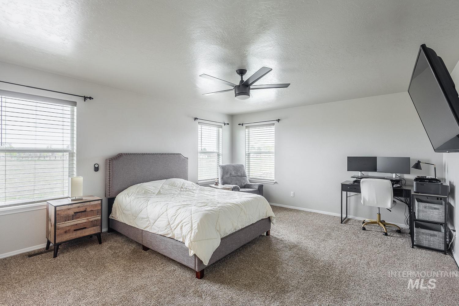2515 Fallcrest Street Caldwell, ID 83607 - Photo 23 of 48 Bedroom featuring a desk, a textured ceiling, a ceiling fan, and carpet flooring