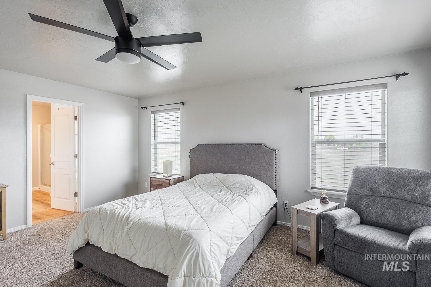 2515 Fallcrest Street Caldwell, ID 83607 - Photo 24 of 48 Bedroom with light colored carpet, connected bathroom, ceiling fan, and a textured ceiling