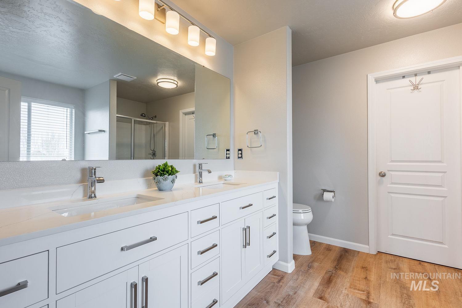 2515 Fallcrest Street Caldwell, ID 83607 - Photo 25 of 48 Full bath with double vanity, a stall shower, and light wood-style floors