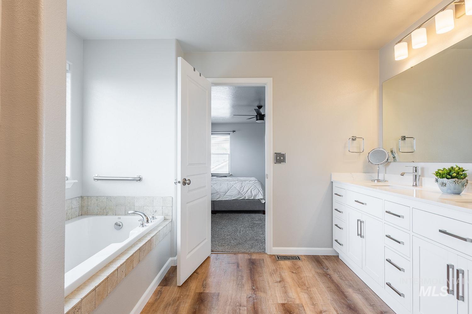 2515 Fallcrest Street Caldwell, ID 83607 - Photo 27 of 48 Bathroom with ensuite bath, double vanity, light wood finished floors, and a bath