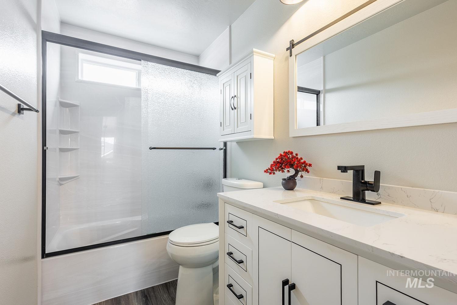 2515 Fallcrest Street Caldwell, ID 83607 - Photo 34 of 48 Full bathroom featuring vanity, combined bath / shower with glass door, and dark wood-style floors