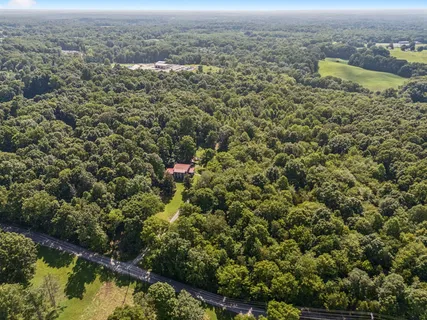 an aerial view of house with yard and mountain view in back
