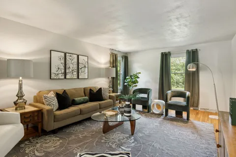 a living room with furniture potted plant and a window