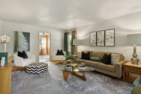 a living room with furniture and a wooden floor