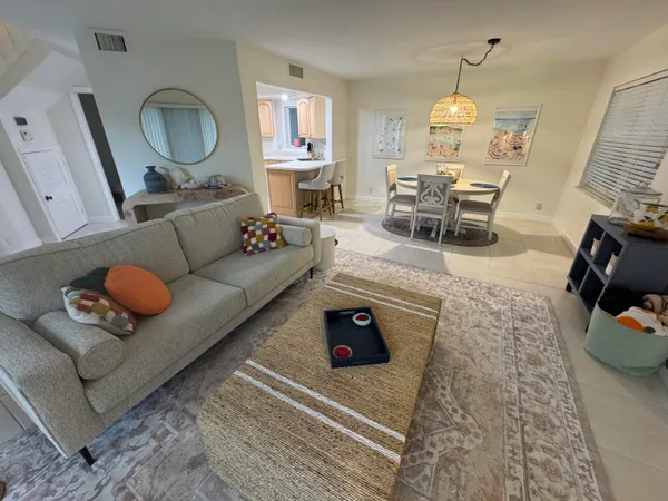 a living room with furniture a flat screen tv and a window