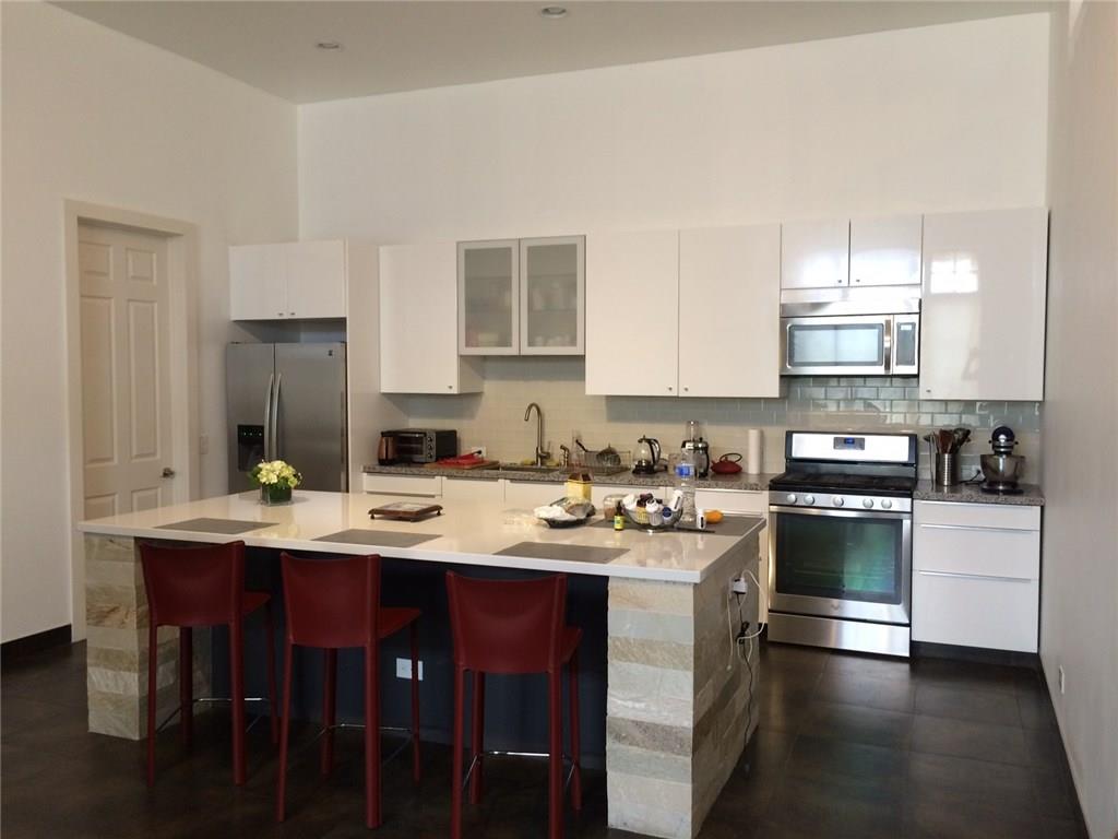 a kitchen with appliances a sink and cabinets