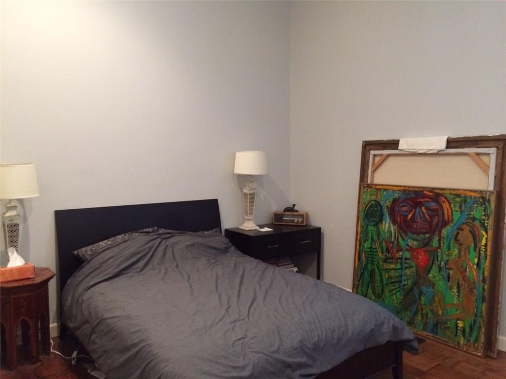 1371 Crampton Street, Unit 120 Dallas, TX 75207 - Photo 6 of 10 a bedroom with a bed and a lamp