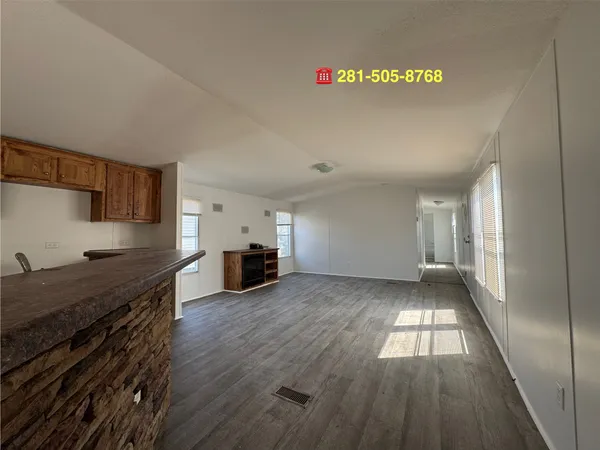 a view of a kitchen with fridge and wooden floor