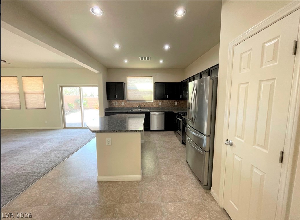 7063 Claythorn Road Las Vegas, NV 89148 - Photo 8 of 30 Granite counters and stainless steel appliances outfit this functional kitchen, opening to a well-lit living space.