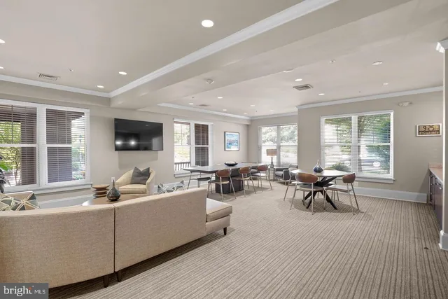 a living room with furniture a flat screen tv and a large window