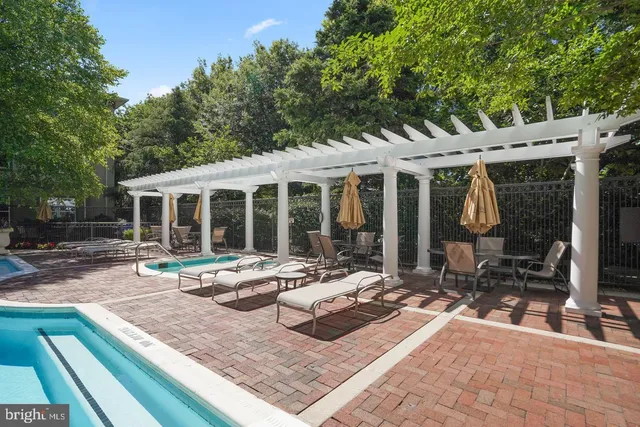 a view of house with backyard outdoor seating and covered with tall trees