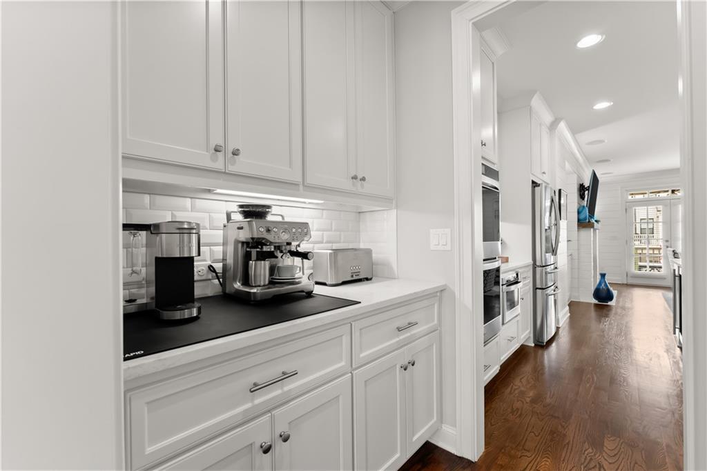 3206 Ridge Towne Place Duluth, GA 30096 - Photo 11 of 42 a kitchen with white cabinets and wooden floor