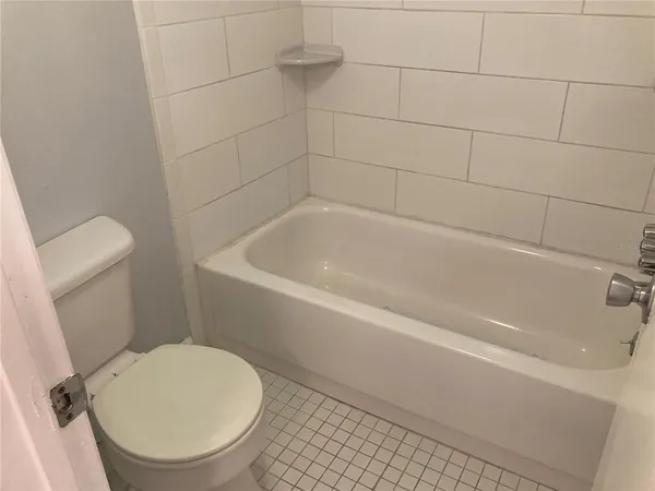 a white bath tub sitting next to a toilet