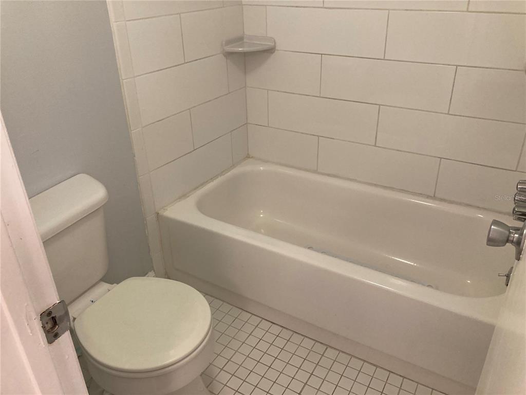 4908 38th Way South, Unit 303 St. Petersburg, FL 33711 - Photo 13 of 14 a white bath tub sitting next to a toilet