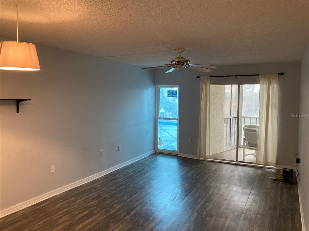 4908 38th Way South, Unit 303 St. Petersburg, FL 33711 - Photo 4 of 14 an empty room with wooden floor and windows