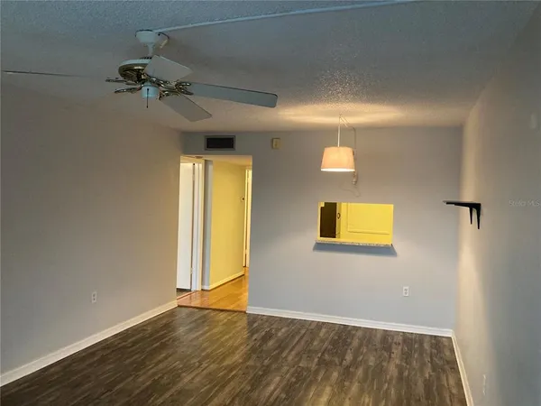 an empty room with a window and wooden floor