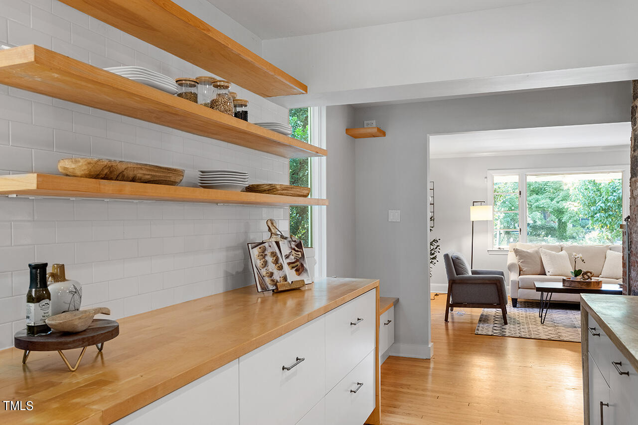 1607 Lorraine Road Raleigh, NC 27607 - Photo 10 of 37 Floating shelves, tile backsplash and butcher block countertop add to the beauty and functionality of the kitchen.
