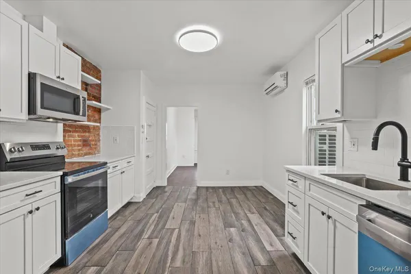a kitchen with a sink wooden floor and stainless steel appliances