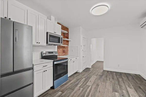 a kitchen with a refrigerator stove and wooden cabinets