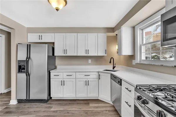 a kitchen with stainless steel appliances granite countertop a sink stove and refrigerator