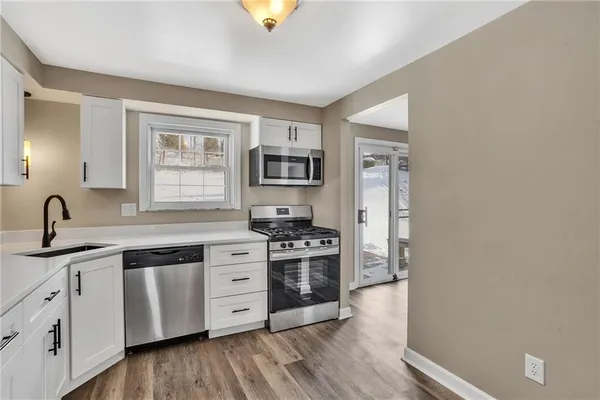 a kitchen with a stove a sink and a microwave