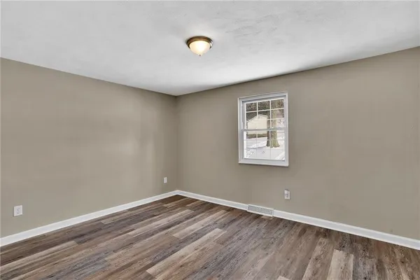 a view of a room with wooden floor and window