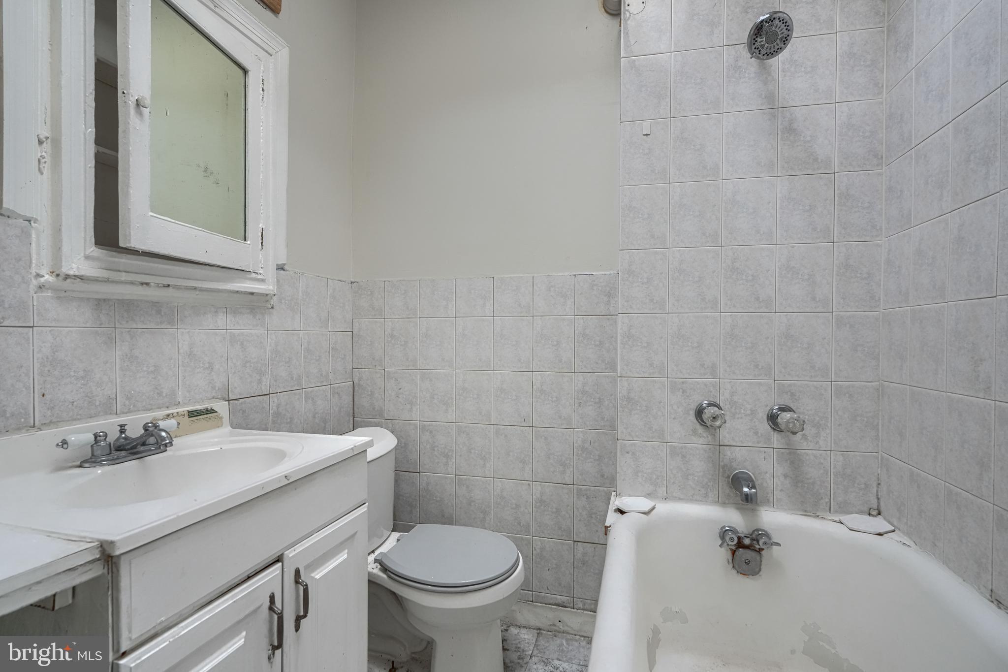 4806 Reisterstown Road Baltimore, MD 21215 - Photo 28 of 34 a bathroom with a sink toilet and a mirror