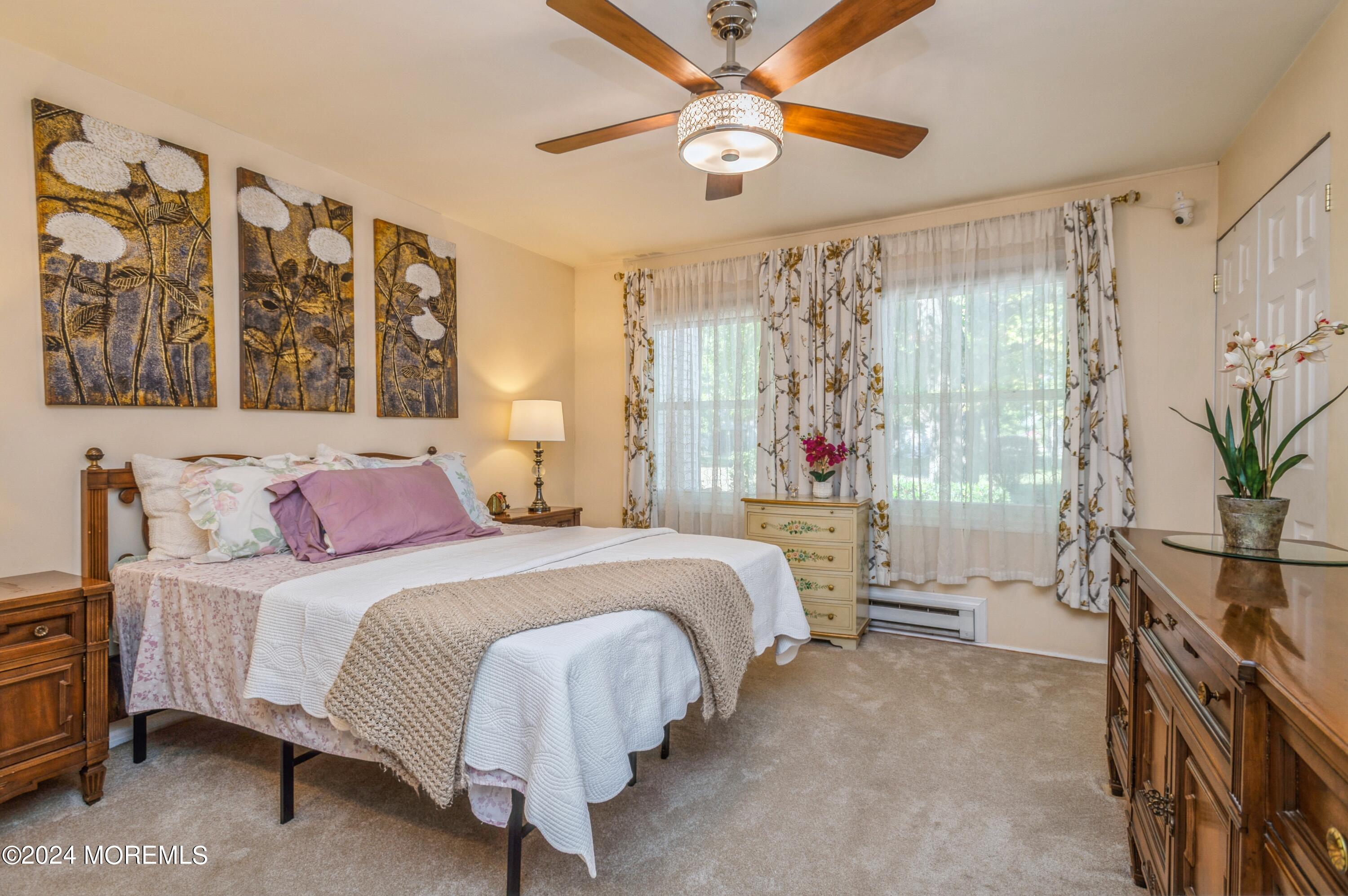 147 B Cours De Pasteur, Unit 1000 Freehold, NJ 07728 - Photo 15 of 28 a bedroom with a large bed and a chandelier