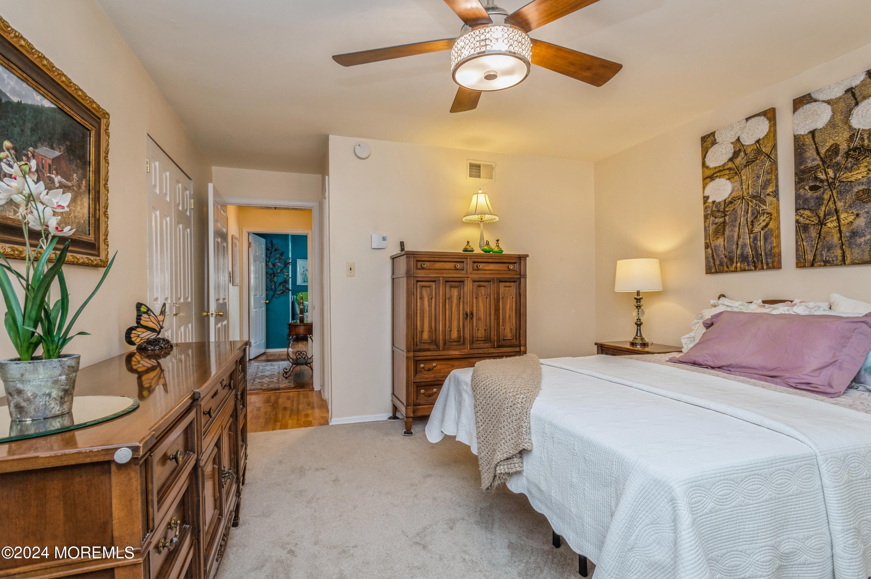 147 B Cours De Pasteur, Unit 1000 Freehold, NJ 07728 - Photo 16 of 28 a bedroom with a bed and wooden floor