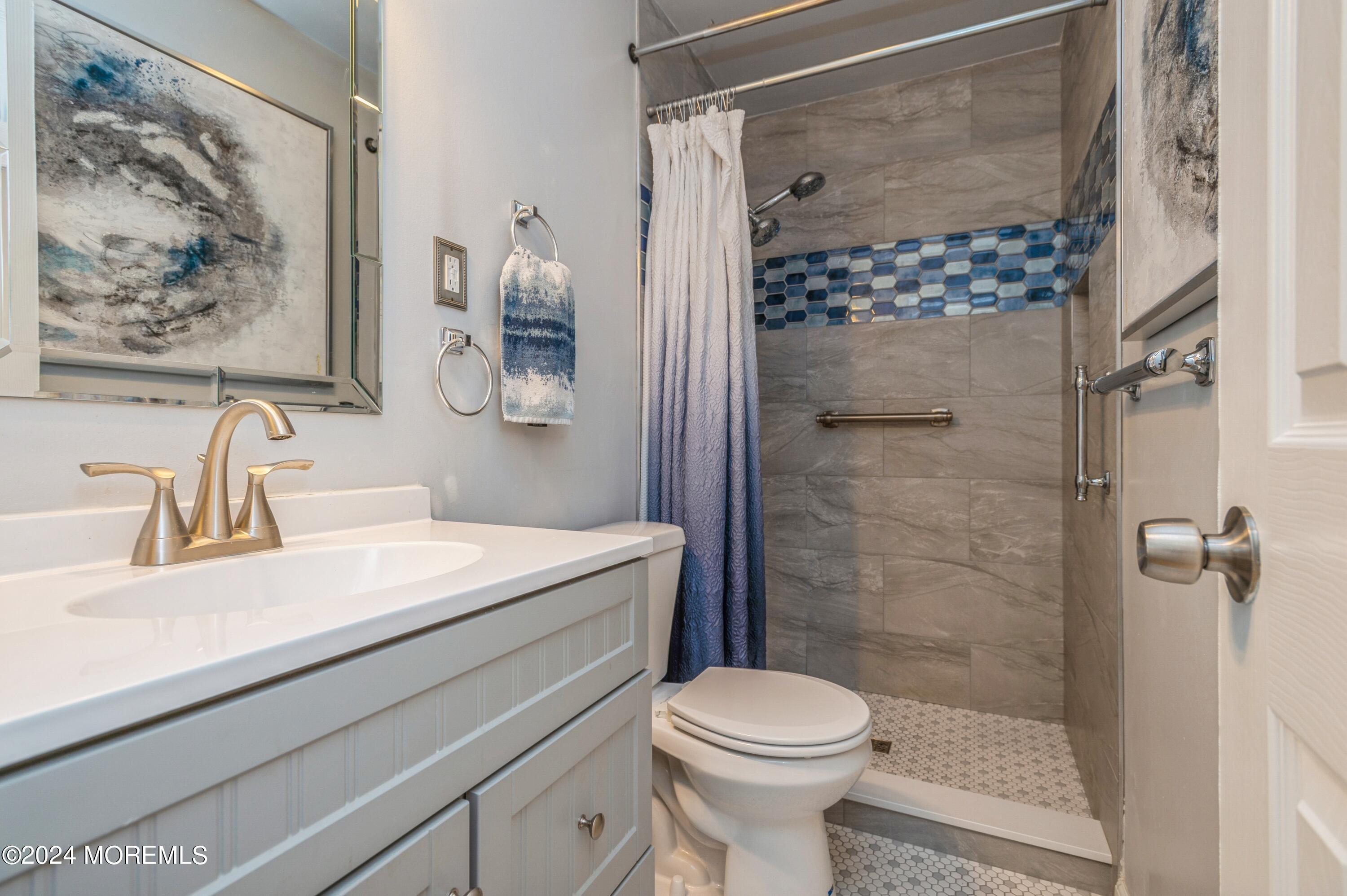 147 B Cours De Pasteur, Unit 1000 Freehold, NJ 07728 - Photo 17 of 28 a bathroom with a sink a toilet and shower