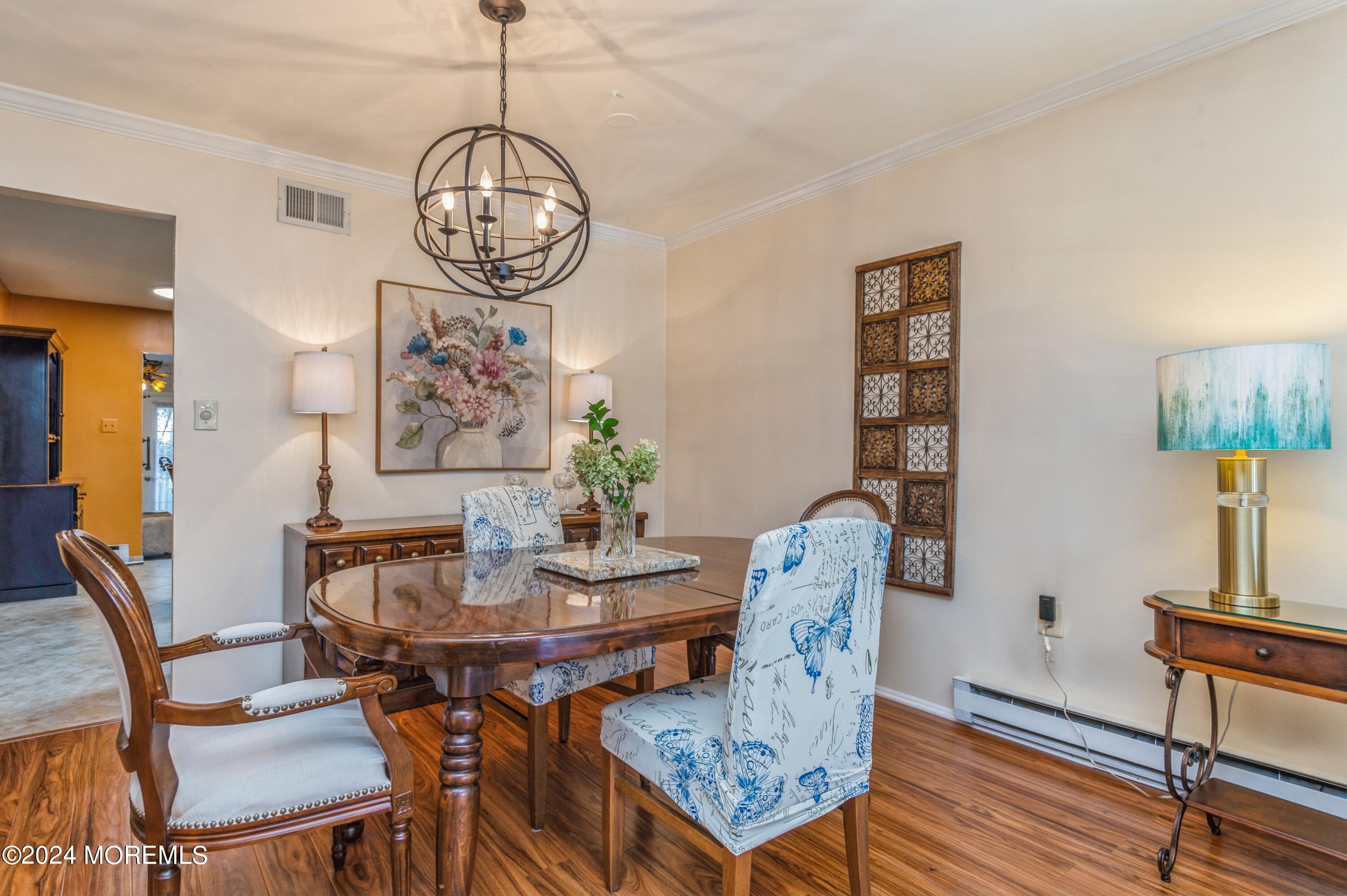 147 B Cours De Pasteur, Unit 1000 Freehold, NJ 07728 - Photo 6 of 28 a view of a dining room with furniture wooden floor and a chandelier