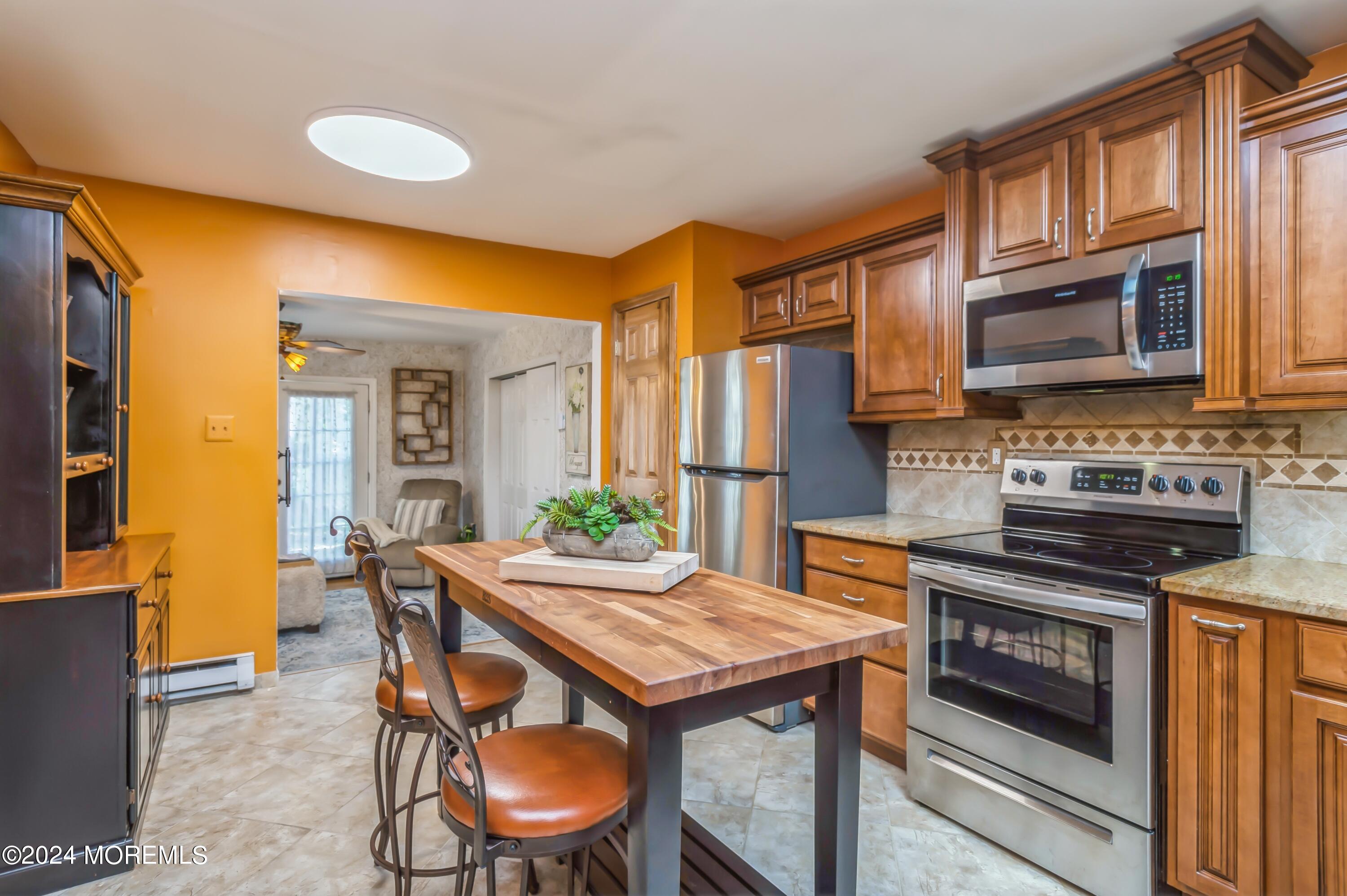 147 B Cours De Pasteur, Unit 1000 Freehold, NJ 07728 - Photo 9 of 28 a kitchen with a table chairs and a refrigerator