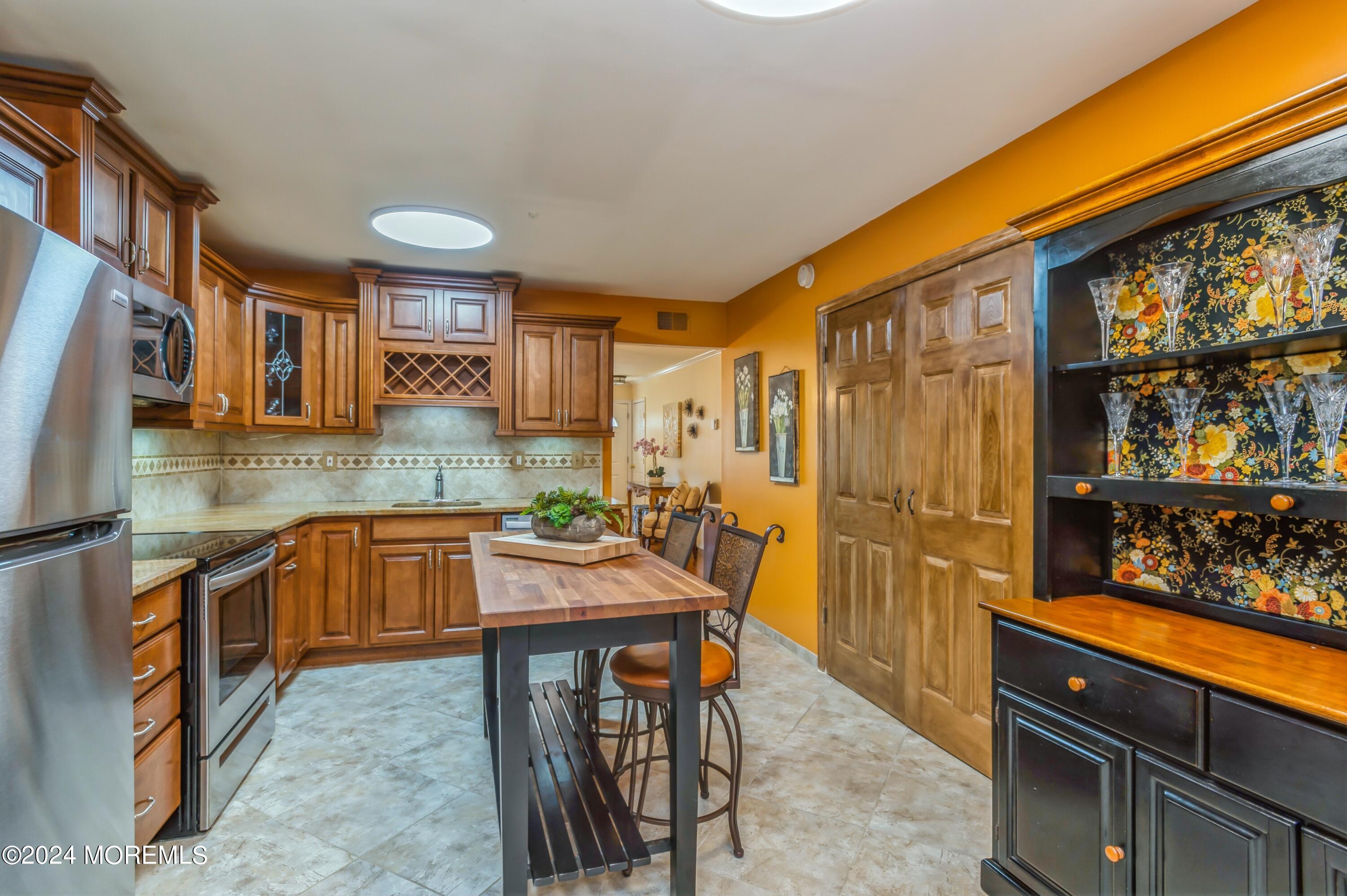 147 B Cours De Pasteur, Unit 1000 Freehold, NJ 07728 - Photo 10 of 28 a kitchen with stainless steel appliances granite countertop a stove a sink and a refrigerator