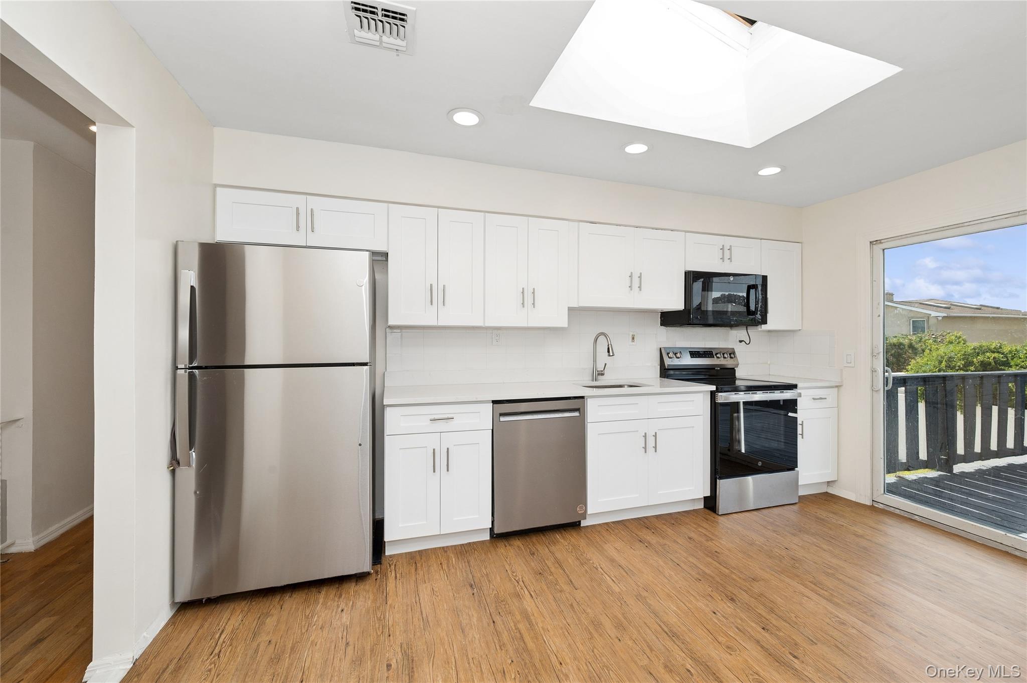 2625 Riverside Drive Wantagh, NY 11793 - Photo 8 of 20 a kitchen with stainless steel appliances granite countertop a refrigerator stove a sink dishwasher and a refrigerator with wooden floor