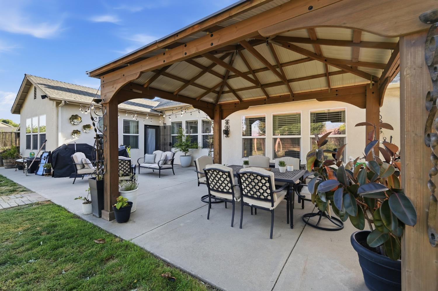 2220 Ellison Drive Modesto, CA 95355 - Photo 46 of 53 a view of a patio with table and chairs potted plants and floor to ceiling window