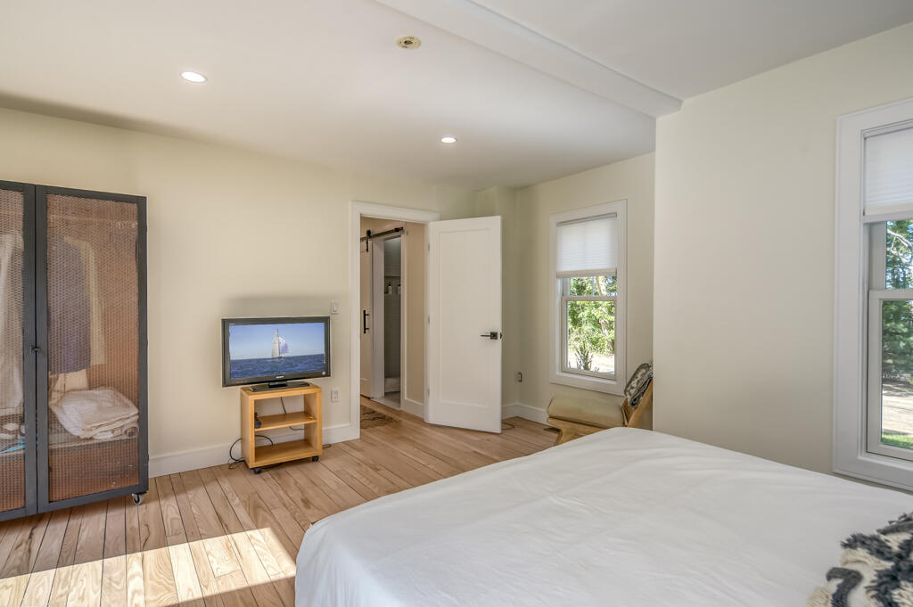 99 The Boulevard Edgartown, MA 02539 - Photo 15 of 35 a bedroom with bed a mirror and a window