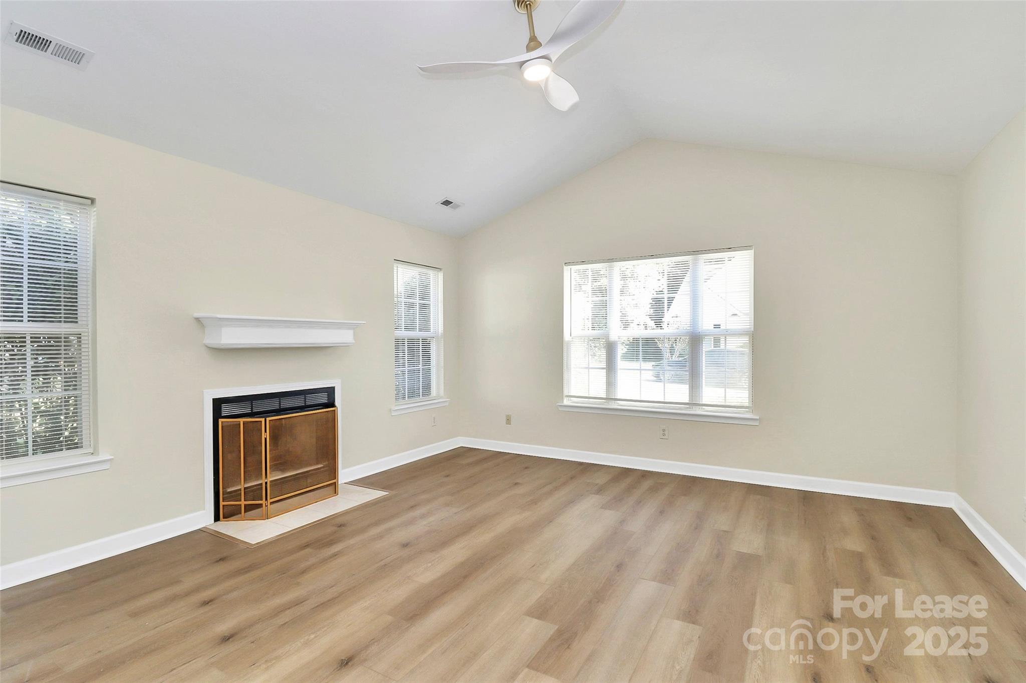 6320 Fresh Wind Avenue Charlotte, NC 28212 - Photo 7 of 31 a view of an empty room with wooden floor fireplace and a window