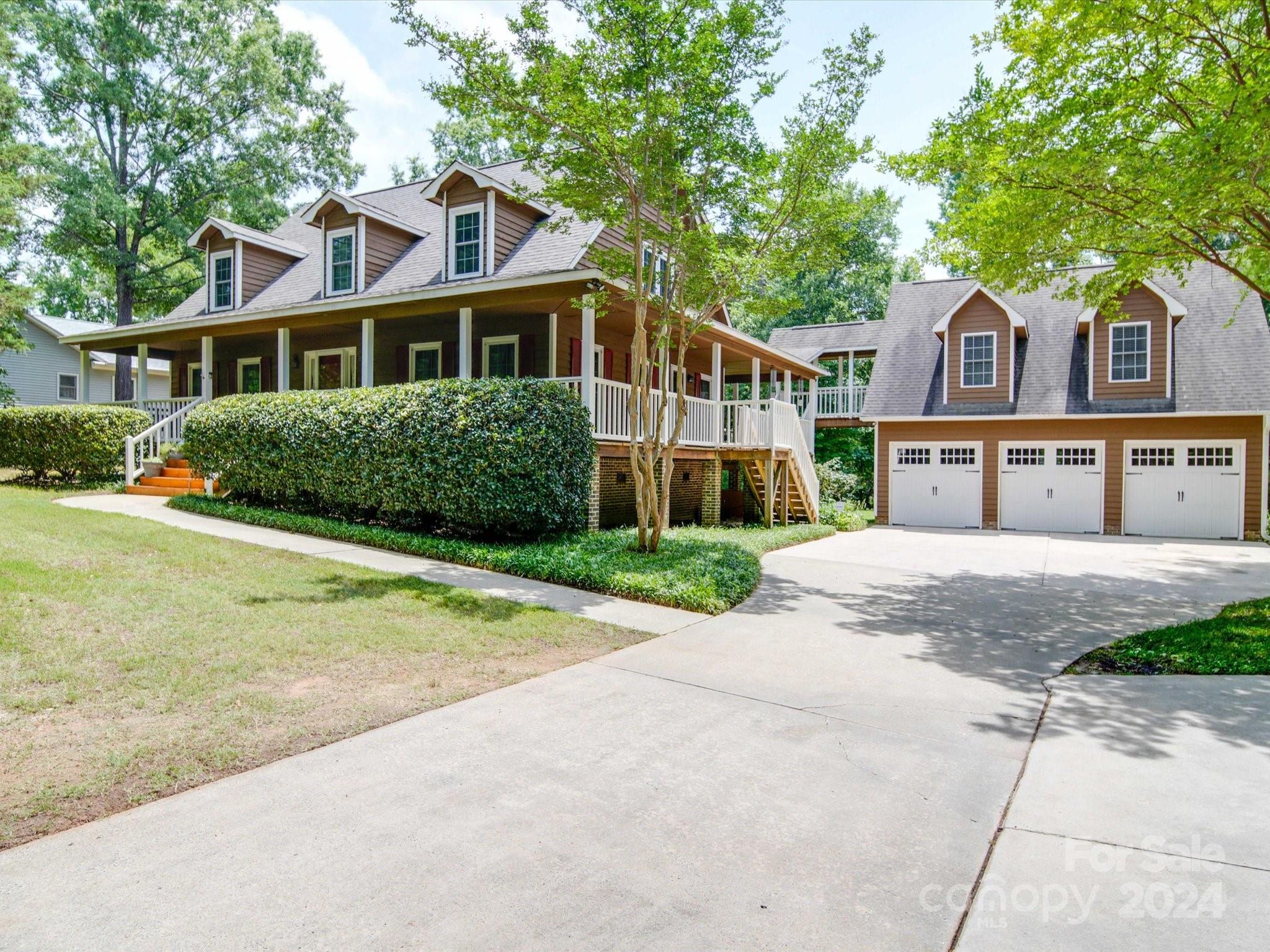 1557 Woodcroft Drive Fort Mill, SC 29708 - Photo 2 of 46 a front view of a house with a garden and trees