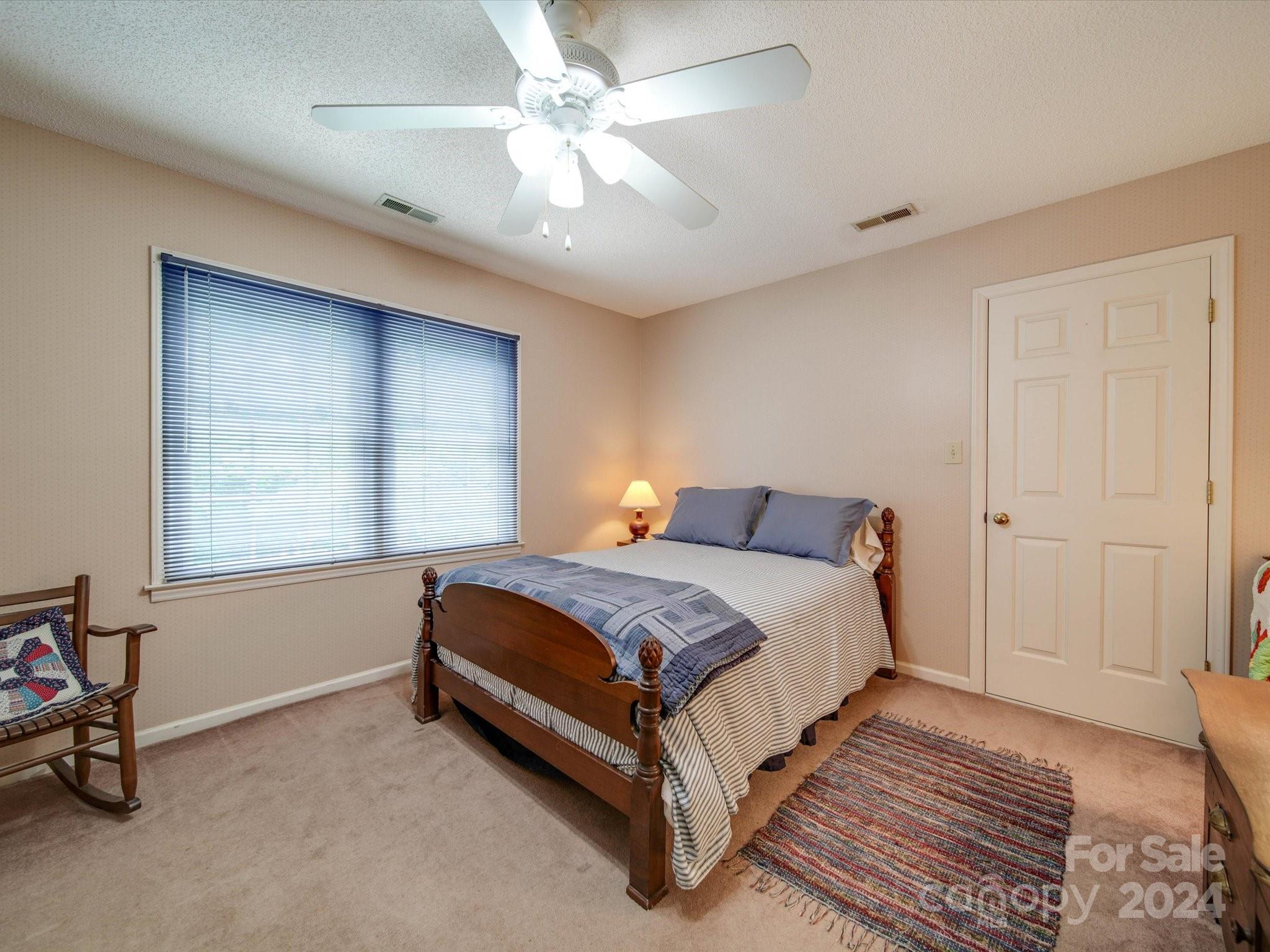 1557 Woodcroft Drive Fort Mill, SC 29708 - Photo 27 of 46 a bedroom with a bed and a ceiling fan