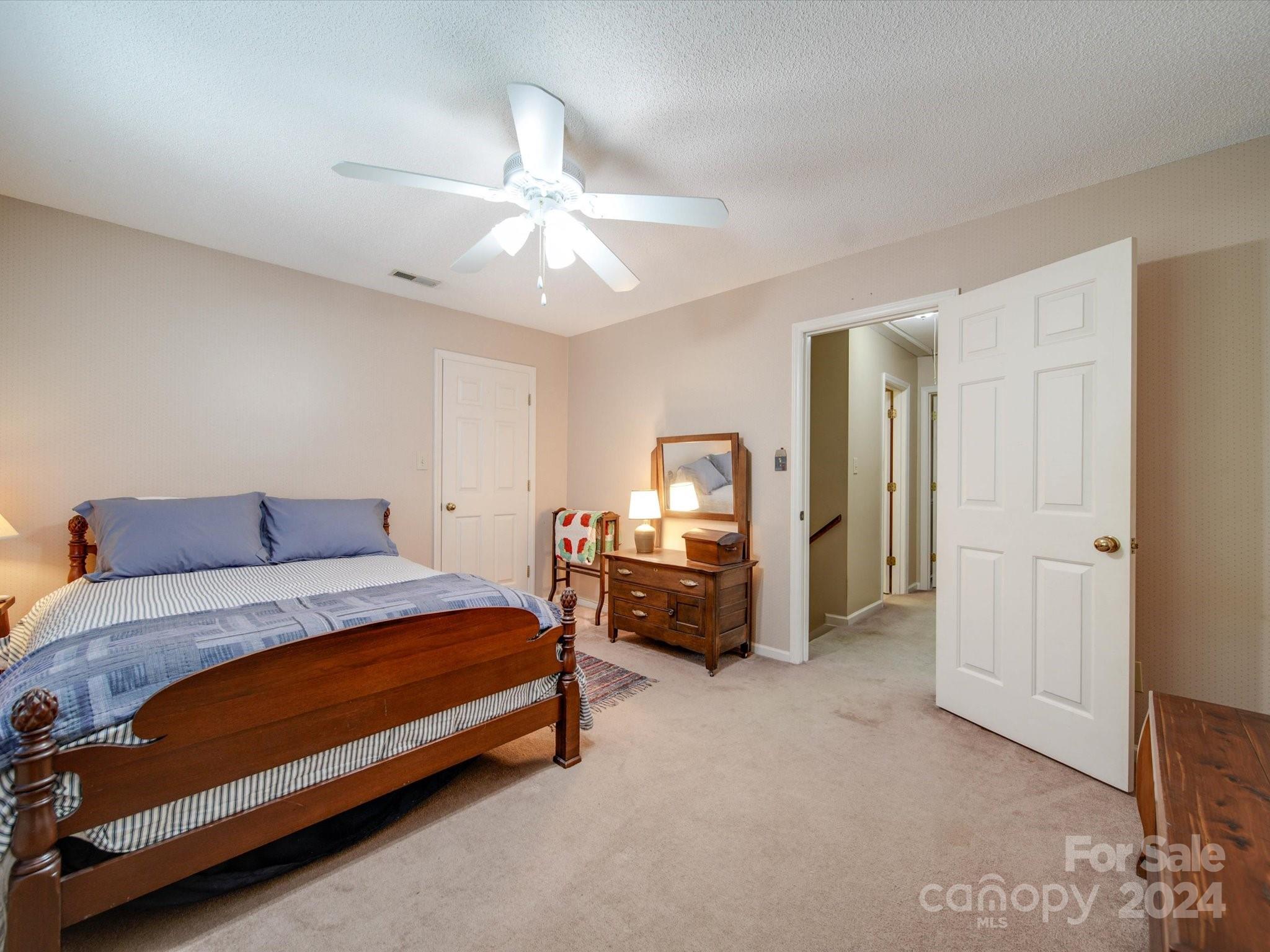 1557 Woodcroft Drive Fort Mill, SC 29708 - Photo 29 of 46 a bedroom with a bed and a chandelier