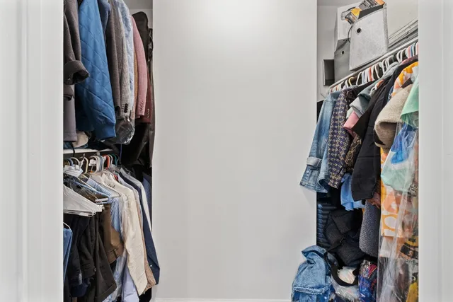 a view of walk in closet with clothes and shoes