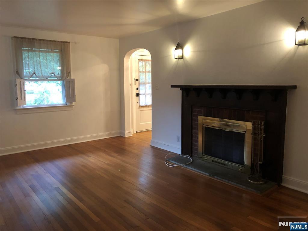 474 Grove Street Ridgewood, NJ 07450 - Photo 9 of 19 an empty room with wooden floor fireplace and windows