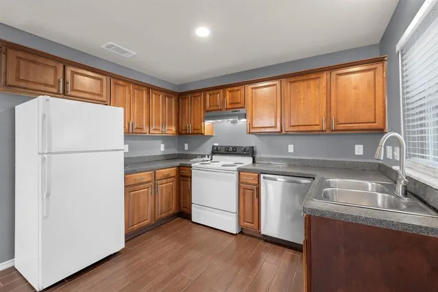 a kitchen with a refrigerator sink and cabinets