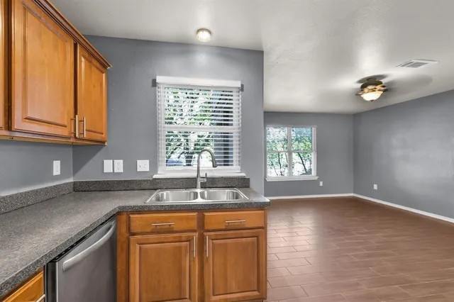 a kitchen with granite countertop wooden cabinets a sink and a window